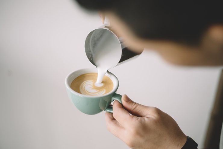 milk being poured into a latte