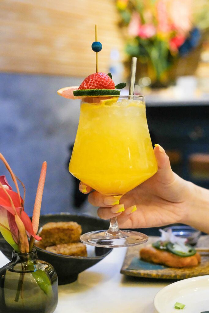 kariyushi club cocktail in hand