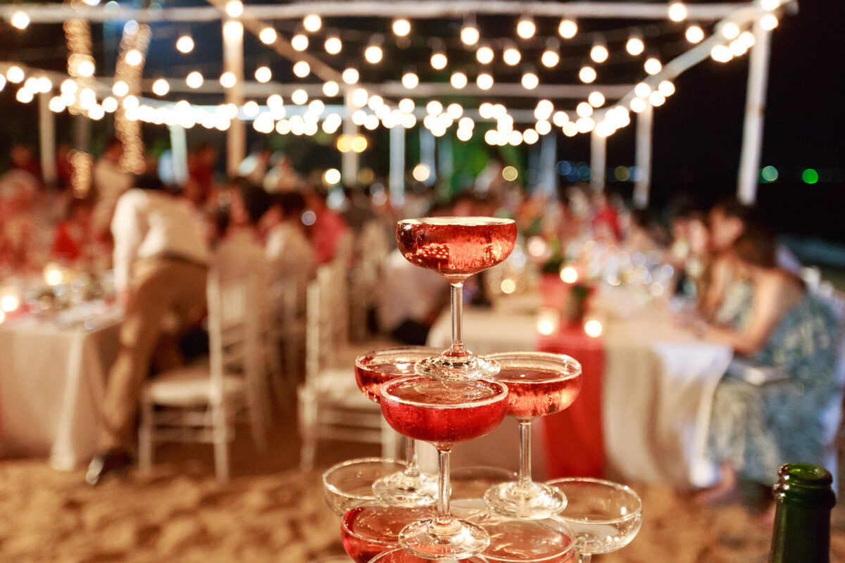 red cocktails stacked in a pyramid at a wedding with sparkly lights