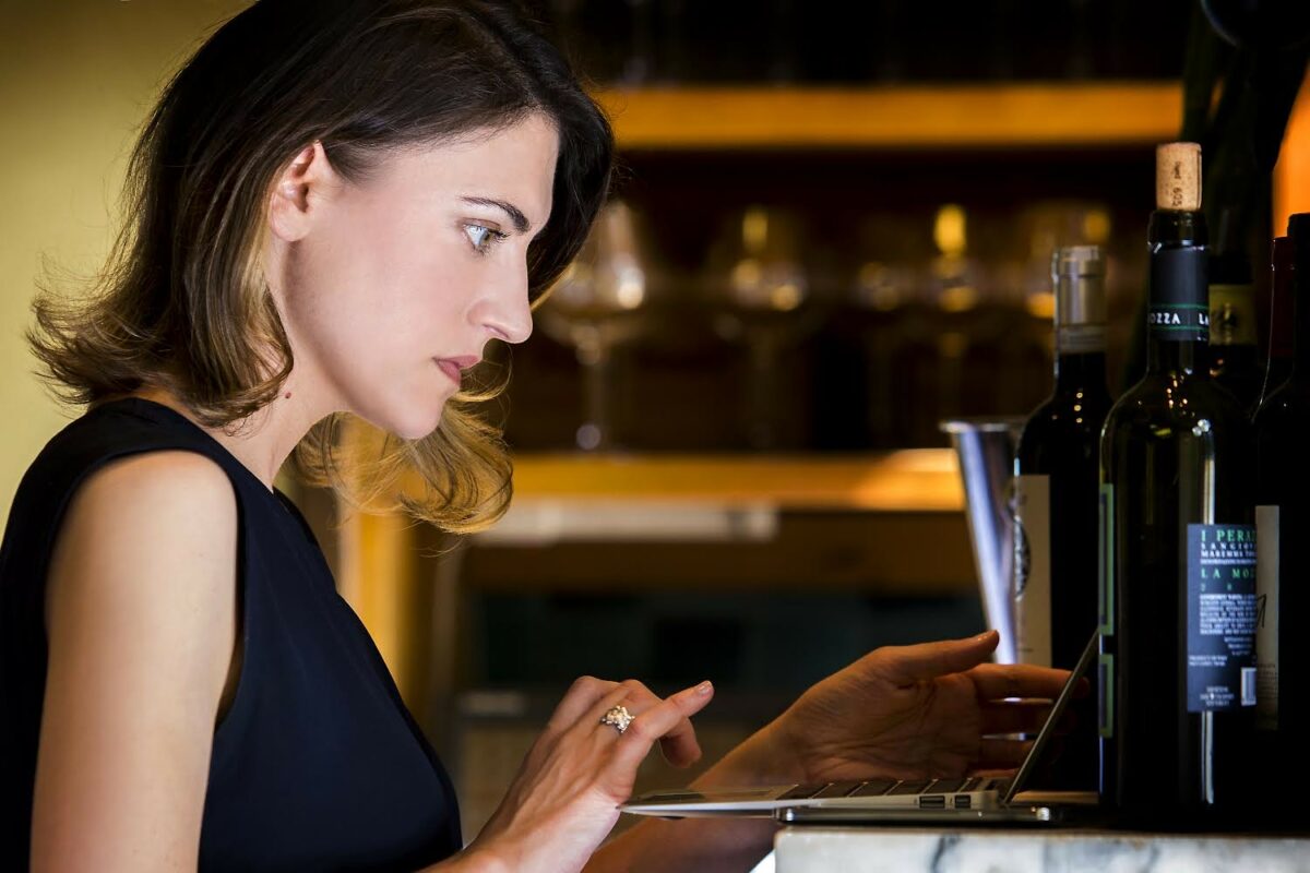 kim reed sits at a bar with her laptop open