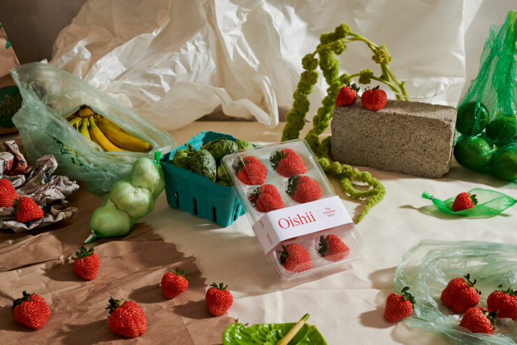 oishii strawberries scattered around a table with other produce